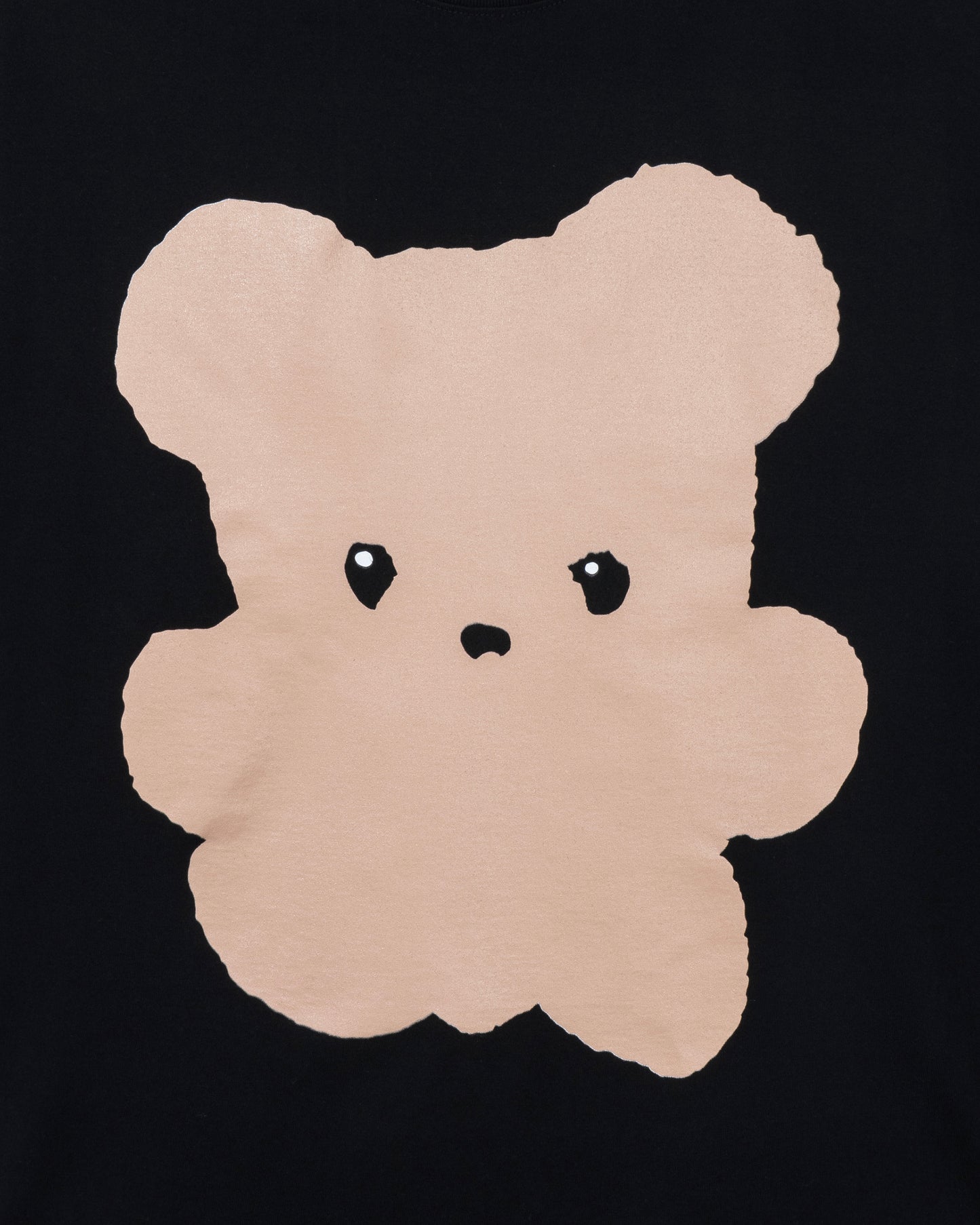 Beige teddy bear-shaped rug on a black background