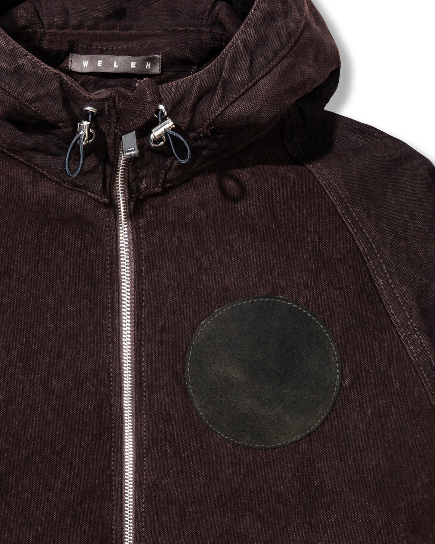 Brown jacket with a circular patch and zipper, featuring the brand 'Wender'.
