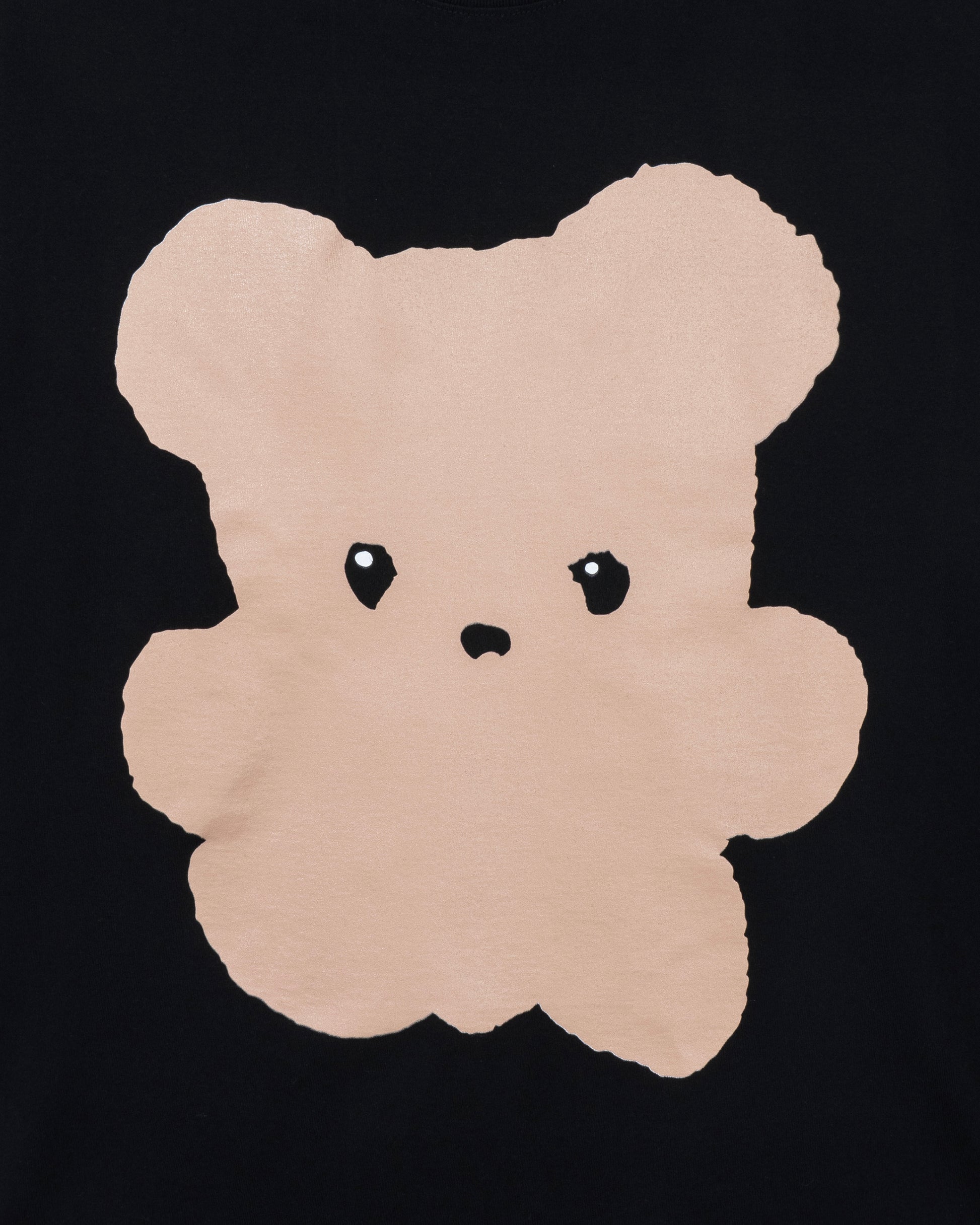 Beige teddy bear-shaped rug on a black background