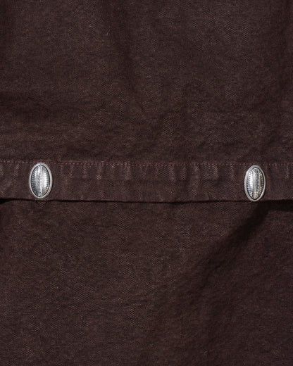 Close-up of a brown fabric with metal buttons on a dark background